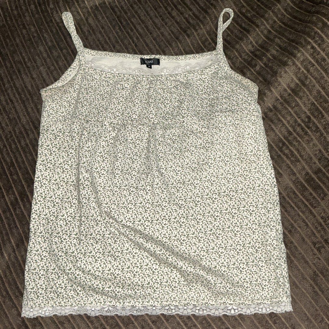 ADIAR Green Floral Cami Top Size M (Category: Sleeveless) located in Quezon City. Submitted by puchi.cat (Listing ID 1465975117, Image 1). Description: - Brand/Style: ADIAR white cami top with green floral print - Details: Delicate lace trim on neckline and hem, babydoll style with gathered bodice - Size: Tag size M - Material: Lightweight and breathable, ideal for layering or solo wear - Condition: Excellent pre-loved condition.