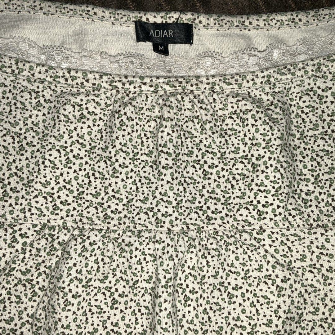 ADIAR Green Floral Cami Top Size M (Category: Sleeveless) located in Quezon City. Submitted by puchi.cat (Listing ID 1465975117, Image 2). Description: - Brand/Style: ADIAR white cami top with green floral print - Details: Delicate lace trim on neckline and hem, babydoll style with gathered bodice - Size: Tag size M - Material: Lightweight and breathable, ideal for layering or solo wear - Condition: Excellent pre-loved condition.