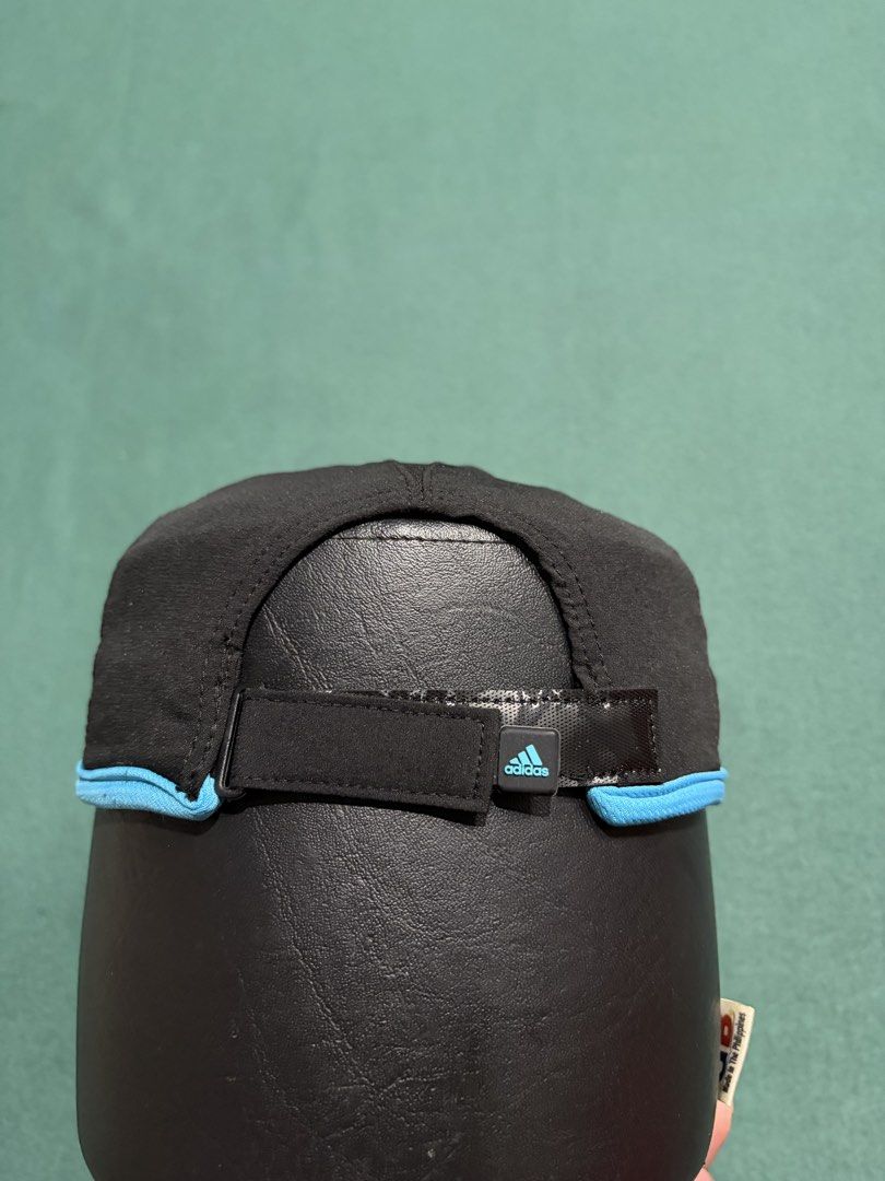 Adidas Adizero Running Cap Black Blue (Category: Caps & Hats) located in Guihulngan. Submitted by fbthriftgoodsniace (Listing ID 1466013482, Image 3). Description: Black Adidas Adizero running cap with vibrant blue piping along the brim. Silver embroidered Adidas logo on the front, adizero text branding on the side. Adjustable hook-and-loop strap in the back featuring a small rubber Adidas tag. Lightweight athletic material with an inner sweatban