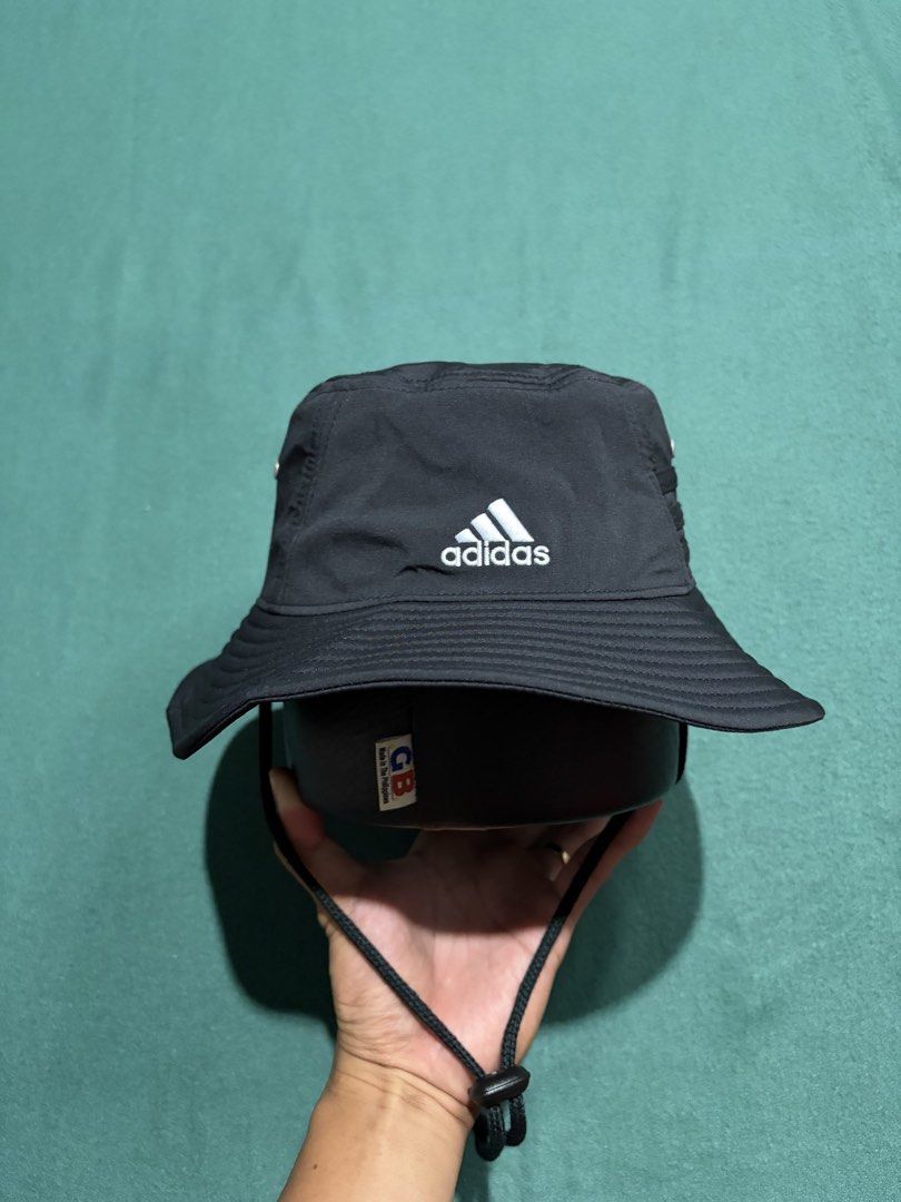 Adidas Aeroready Black Bucket Hat (Category: Caps & Hats) located in Guihulngan. Submitted by fbthriftgoodsniace (Listing ID 1466004836, Image 1). Description: - Brand: Adidas - Color: Classic black with white embroidered logo - Tech: Aeroready sweatband keeps you dry - Comfort: Lightweight polyester blend with mesh lining - Features: Adjustable chin strap with toggle for a secure fit - Condition: Clean inside and out, perfect for outdoor activit
