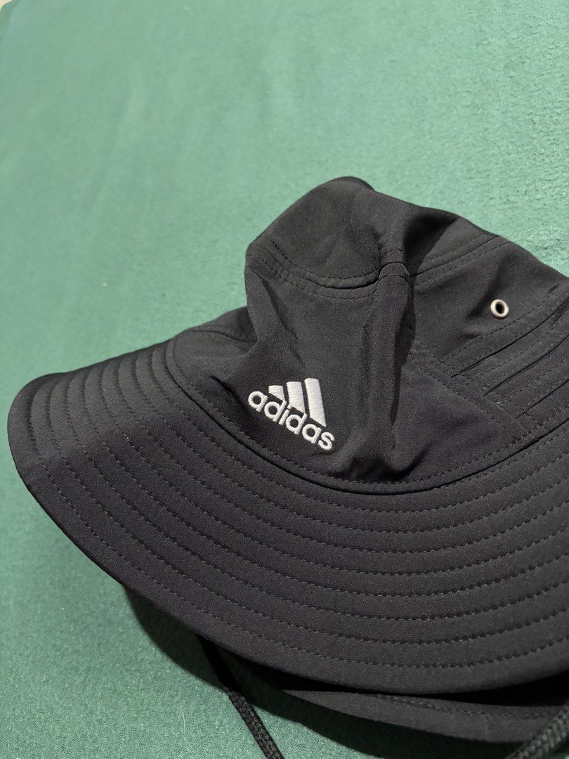 Adidas Aeroready Black Bucket Hat (Category: Caps & Hats) located in Guihulngan. Submitted by fbthriftgoodsniace (Listing ID 1466004836, Image 3). Description: - Brand: Adidas - Color: Classic black with white embroidered logo - Tech: Aeroready sweatband keeps you dry - Comfort: Lightweight polyester blend with mesh lining - Features: Adjustable chin strap with toggle for a secure fit - Condition: Clean inside and out, perfect for outdoor activit