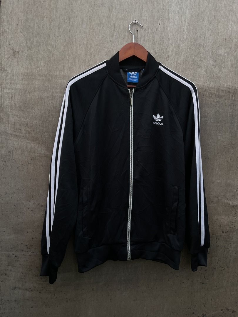 Adidas Black Track Jacket (Category: Coats, Jackets and Outerwear) located in Talisay. Submitted by justindanielle17 (Listing ID 1466037474, Image 1). Description: - Authentic black Adidas track jacket with full-zip closure -21 x 27.5 inches in dimensions -Excellent Conditions -9.8/10 Color rate - Features iconic white three-stripe detailing down the sleeves - Embroidered Adidas trefoil logo on the chest - Comfortable ribbed cuffs and hem for a s