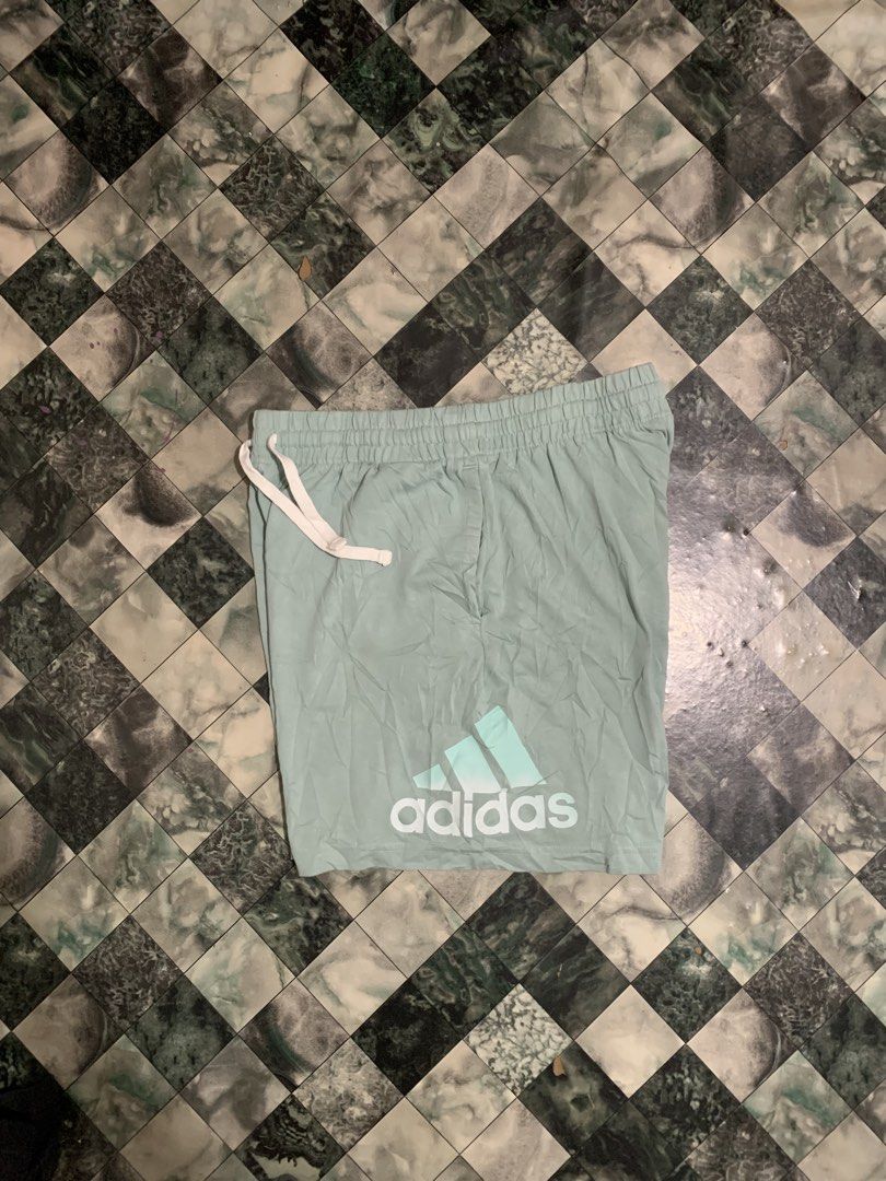 Adidas light green athletic shorts with drawstring (Category: Shorts) located in Cebu City. Submitted by tangubrhia45277 (Listing ID 1466082453, Image 3). Description: - Brand: Adidas - Color: Light green with white details - Material: 70% cotton, 30% recycled polyester - Features: Elastic waistband, white drawstrings, and logo graphic near hem - Condition: Brand new with tags attached - Ideal for: Workouts or casual lounging.
