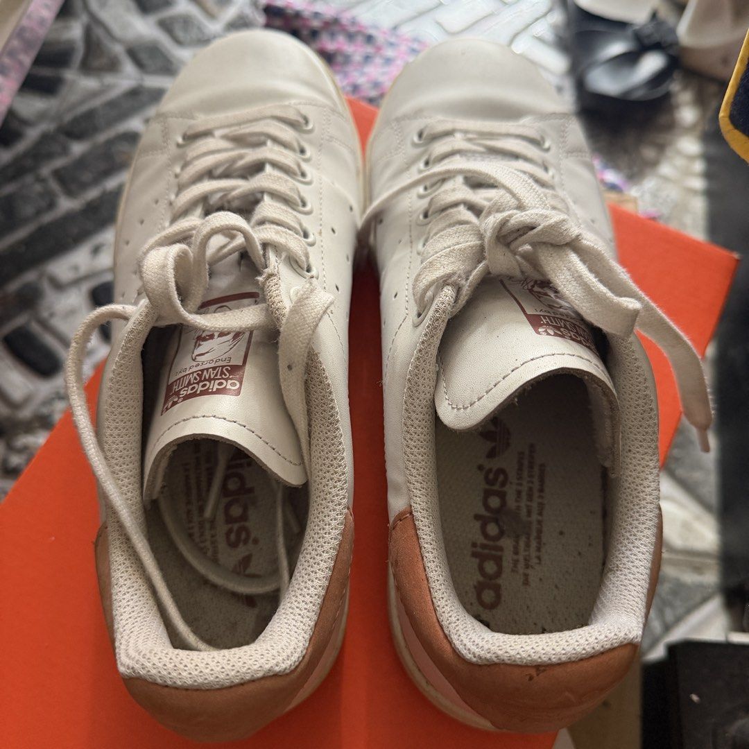 Adidas Stan Smith White Tan Sneakers (Category: Sneakers) located in Manila. Submitted by basiliocla11530 (Listing ID 1466011748, Image 3). Description: - Brand: Adidas Stan Smith - Color: White leather with tan suede heel tabs - Features: Perforated three stripes, signature tongue portrait tag, and embossed trefoil logo - Condition: Great everyday casual shoes with minor wear on soles from normal use - Inclusions: White laces and matching inner 