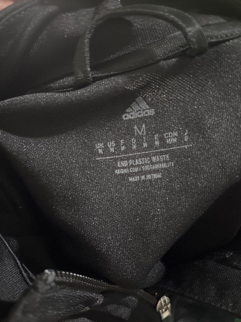 Adidas Tiro Jacket Black Gold (Category: Coats, Jackets and Outerwear) located in Manila. Submitted by uuwoooogghreiri (Listing ID 1466039529, Image 3). Description: - Brand: Adidas Tiro - Color: Black with gold details - Design: Full zip closure, stand-up collar, and classic three stripes on sleeves - Features: Ribbed mesh paneling on upper arms for breathability - Fit: Standard fit, lightweight material - Best for: Workouts, training sessions, 