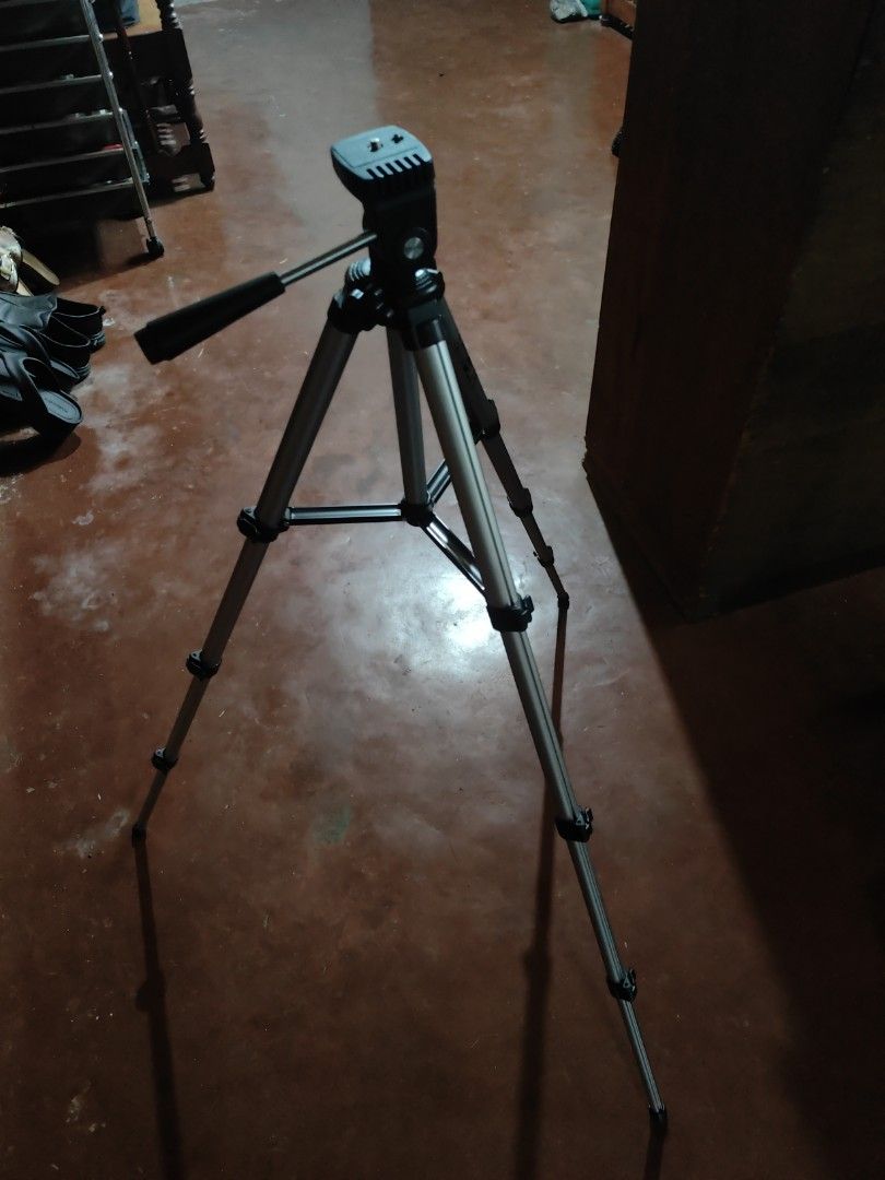 Adjustable Camera Tripod with Pan Head (Category: Tripods & Monopods) located in Manila. Submitted by wuxue998 (Listing ID 1466054685, Image 1). Description: - Color: Silver and black - Design: Sturdy metal construction that folds compactly for easy transport - Legs: Three-section extendable legs with secure flip locks - Head: Built-in pan head with handle for smooth video panning - Mount: Standard mounting plate included.
