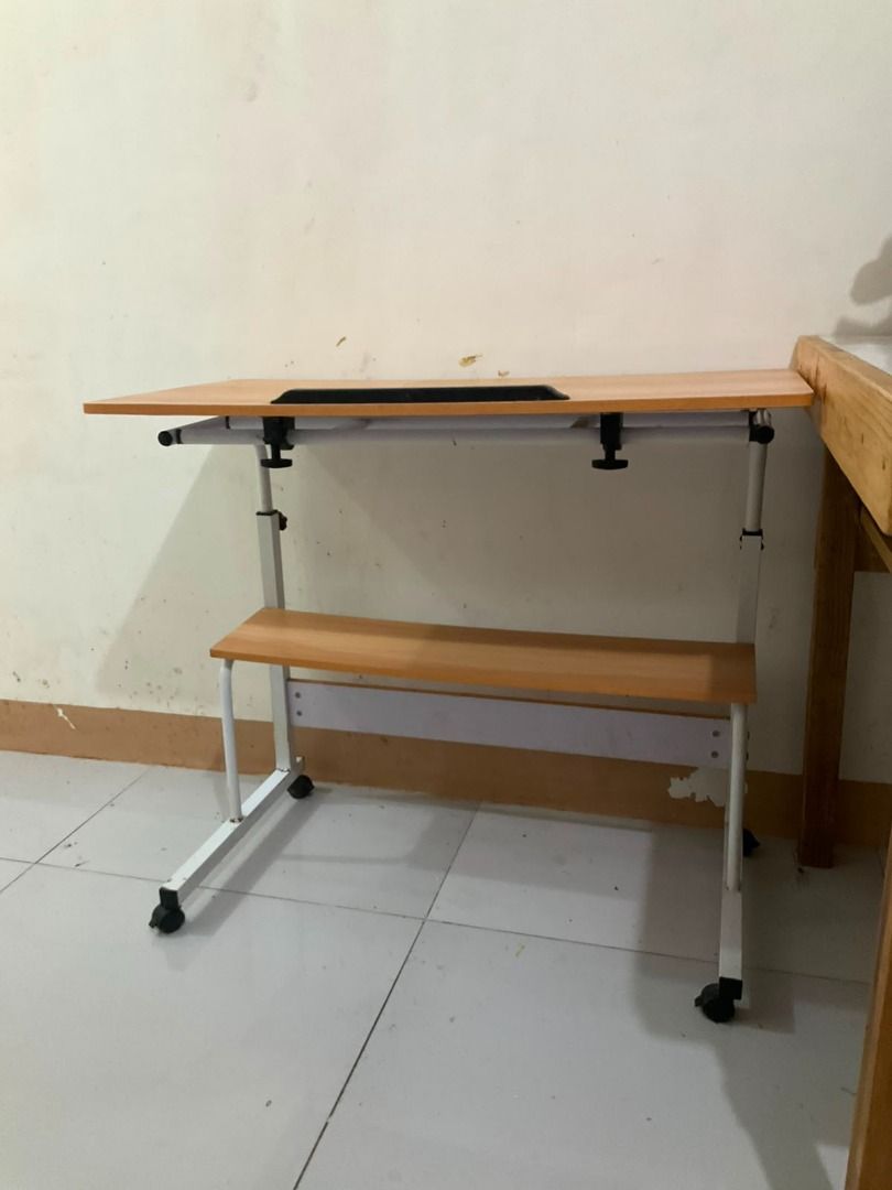 Adjustable Rolling Laptop Desk with Storage Shelf (Category: Tables & Sets) located in Jaen. Submitted by blaire.mayoph (Listing ID 1466120151, Image 3). Description: Selling our adjustable rolling laptop desk with storage shelf. Light wood finish yung tabletop with a white metal frame, and may wheels kaya madaling ilipat from one room to another. Details: • Adjustable rolling laptop/computer desk • Light wood finish tabletop • White metal frame 