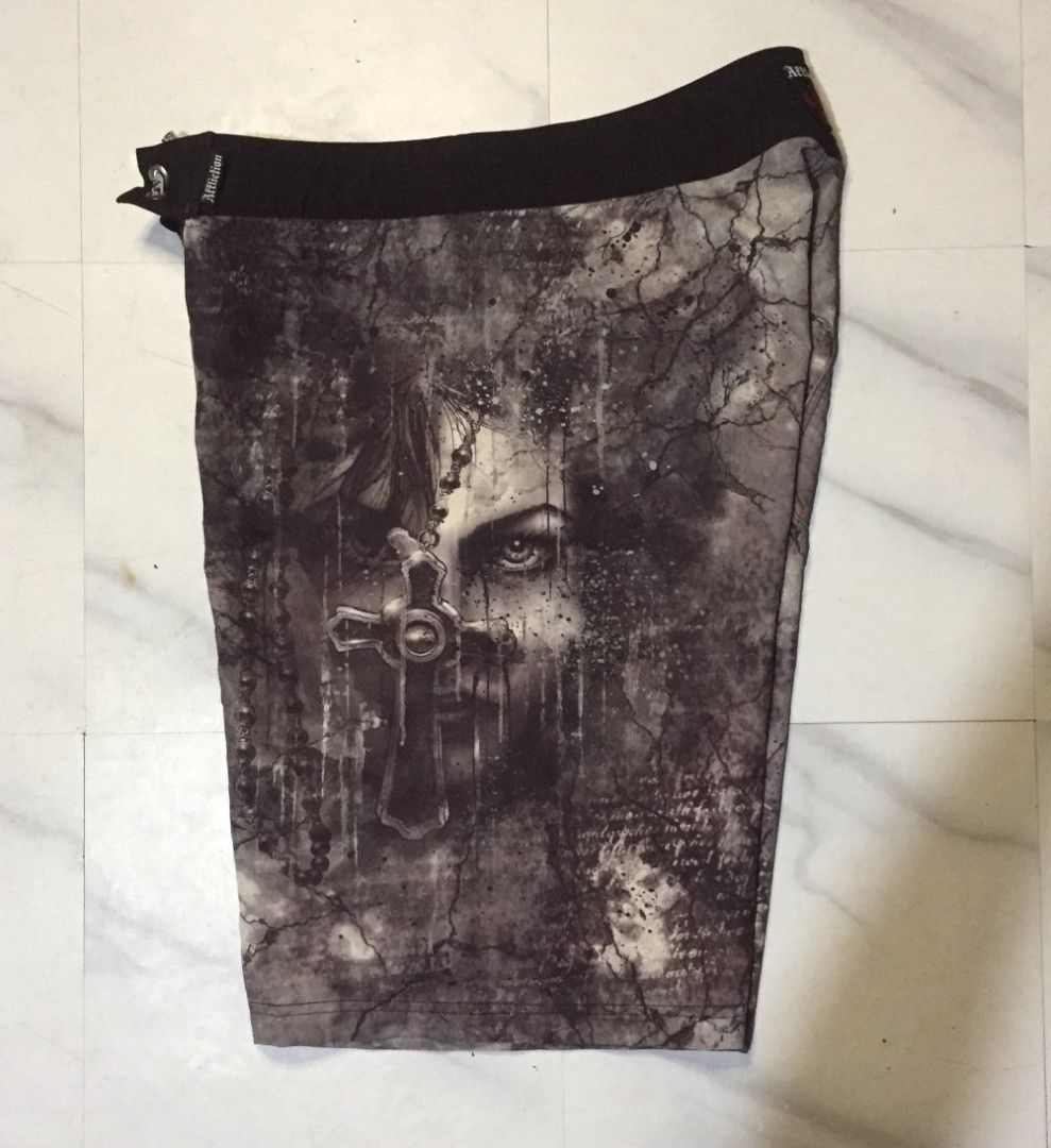 Affliction Graphic Cross Board Shorts (Category: Swim Trunks & Board Shorts) located in Imus. Submitted by thrifts_select (Listing ID 1465996843, Image 1). Description: - Brand: Affliction - Color: Black and grey - Design: Bold cross graphic with cracked stone texture and fleur-de-lis back patch - Closure: Front lace-up with branded metal eyelets - Details: Signature Affliction embroidery on inner and outer waistband - Condition: Great quality, p