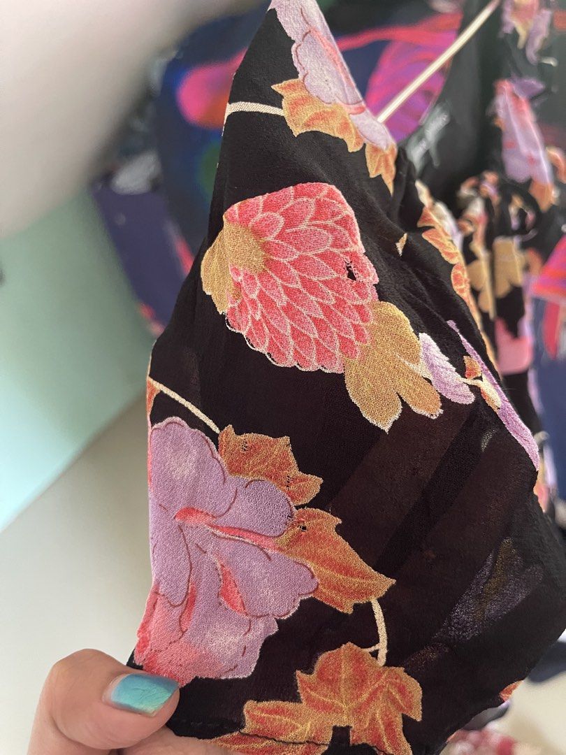 Aimee D Petites floral black blouse (Category: Blouses) located in Baybay. Submitted by shikita27906 (Listing ID 1466032983, Image 3). Description: - Brand: Aimee D Petites - Size: L but can fit M - Design: Black with pink, purple, and green floral print - Details: Scoop neckline with drawstring tie, short sleeves, lightweight fabric - Condition: Noticeable small fabric holes and wear near the flowers as shown in photos.