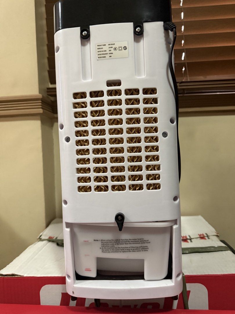 Air Cooler JD-8006 Fan Cooling Unit (Category: Air Conditioning and Heating) located in Imus. Submitted by silentfire-353921 (Listing ID 1465968441, Image 2). Description: - Model: JD-8006 (White and Black) - Power: 65W, 220V - Cooling System: Honeycomb cooling pad at the back for enhanced airflow - Water Tank: Includes clear level indicator and safety warning labels - Controls: Convenient top control buttons - Condition: Works great for cooling 