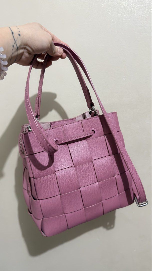 Anne Klein Bucket Bag (Category: Shoulder Bags) located in Las Pinas. Submitted by mharjrahm (Listing ID 1465954106, Image 2). Description: - Style: Woven leather bucket bag with intrecciato-style pattern - Color: Vibrant pink - Closure: Front drawstring with dangling knot ends - Straps: Dual top handles plus a detachable longer side strap - Hardware: Silver-toned - Size & Structure: Medium size with a clean, structured silhouette - Use: Perfect 