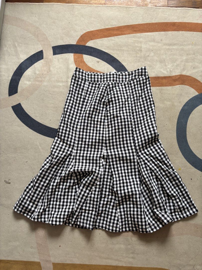 AUN Design+ Black and White Gingham Skirt Size M (Category: Skirts) located in Taguig. Submitted by narulover (Listing ID 1465978730, Image 1). Description: - Brand: AUN Design+ - Size: Medium (tag attached) - Pattern: Classic black and white gingham - Design: Panel construction with a flared hem - Lining: Fully lined interior - Condition: Brand new with tags - Ideal for: Casual weekend outings, picnics, and daily wear.