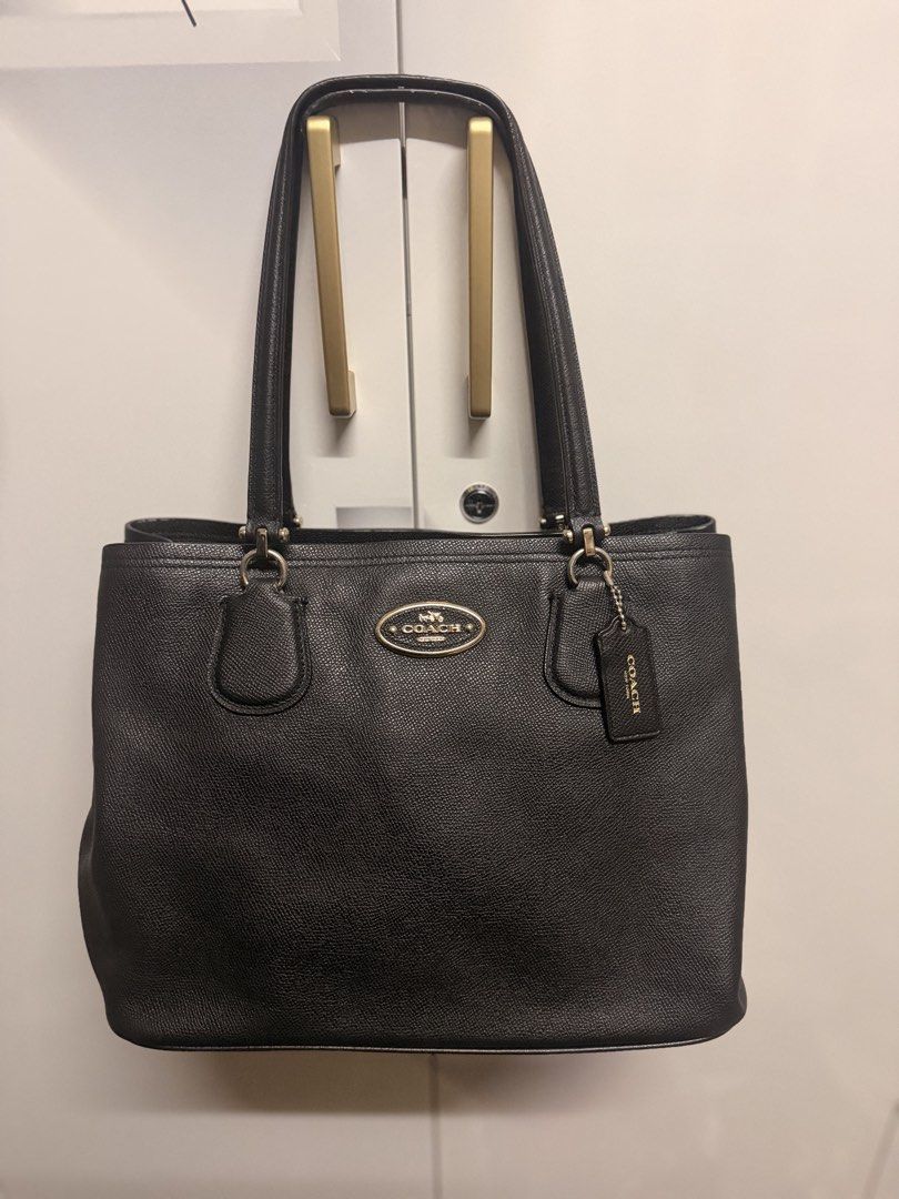 Authentic Coach Black Leather Tote Bag (Category: Luxury Bags & Wallets) located in Zamboanga. Submitted by bags2bags2bags (Listing ID 1465981939, Image 1). Description: - Authentic Coach black pebble leather tote - Elegant gold-tone hardware and iconic oval Coach logo plaque - Includes matching leather hangtag - Comfortable double shoulder straps - Structured base with protective flat bottom - Clean silhouette, ideal for everyday use.