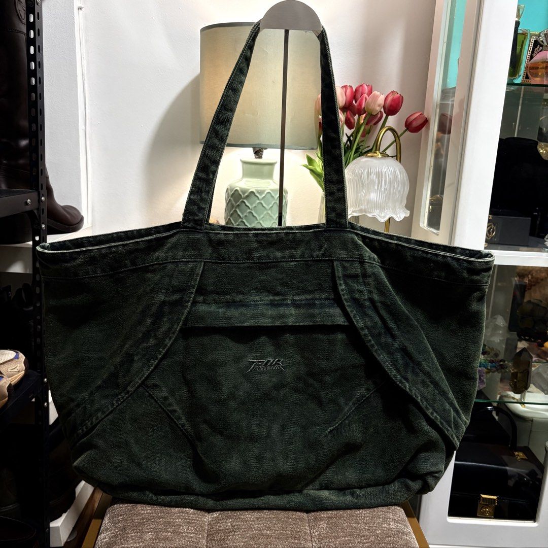 Authentic FAR BIG TOTE BAG_BLUE GREEN (Category: Tote Bags) located in Binangonan. Submitted by makoleksyon (Listing ID 1465897944, Image 1). Description: Material: Made from 100% thick, double-layered cotton denim fabric, giving it a heavy and structured feel. Design Features: It has a distinctive wide, curved panels design on the front with a stylized, embroidered central logo reading "FAR". It also includes a large main storage compartment and