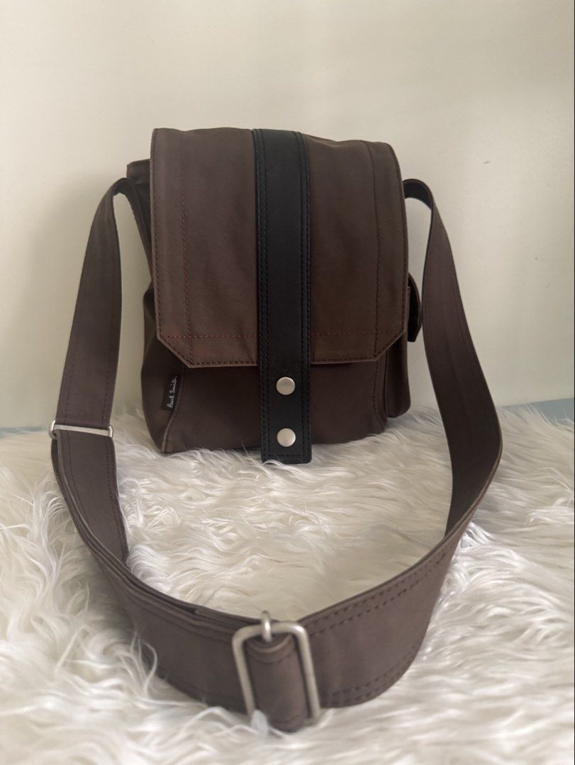 Authentic Paul Smith Brown Canvas Crossbody Bag with Adjustsble Strap (Category: Sling Bags) located in Pasig City. Submitted by topbrandpursuits (Listing ID 1465804920, Image 1). Description: - Authentic Paul Smith crossbody bag in durable brown canvas - Features a striking vertical black leather center stripe - Eye-catching contrast pink stitching on the front flap and side pocket - Convenient side pocket with velcro closure - Adjustable brown 