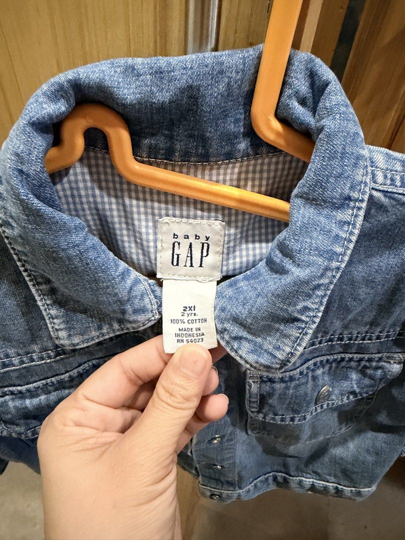 Baby Gap Denim Jacket (Category: Babies & Kids Fashion) located in Quezon City. Submitted by welovedclothing (Listing ID 1466048565, Image 2). Description: - Brand: Baby Gap - Size: 2 Years - Material: 100% Cotton - Color: Classic blue wash with blue & white gingham collar lining - Design: Front button closure, dual chest flap pockets, and large embroidered heart on the back - Origin: Made in Indonesia - Condition: Great little layer for cooler d