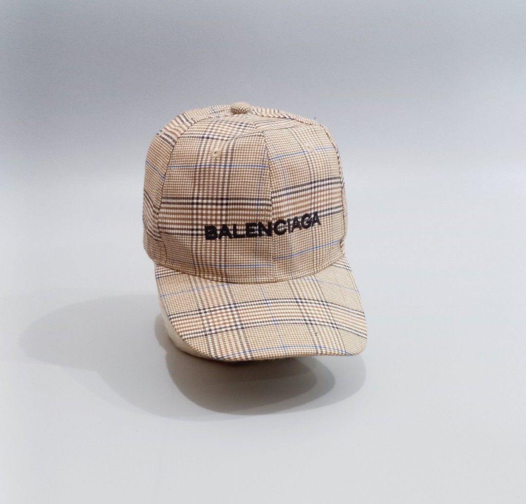 Balenciaga Plaid Check Baseball Cap (Category: Caps & Hats) located in Cebu City. Submitted by MrLiks_123 (Listing ID 1466107593, Image 1). Description: Balenciaga Baseball cap in a stylish beige plaid check pattern - Details: Contrast black embroidered Balenciaga logo on the front - Hardware: Silver-tone metal buckle stamped with the letter 'B' on the adjustable back strap - Construction: Clean fabric with structured panels and top eyelets for b