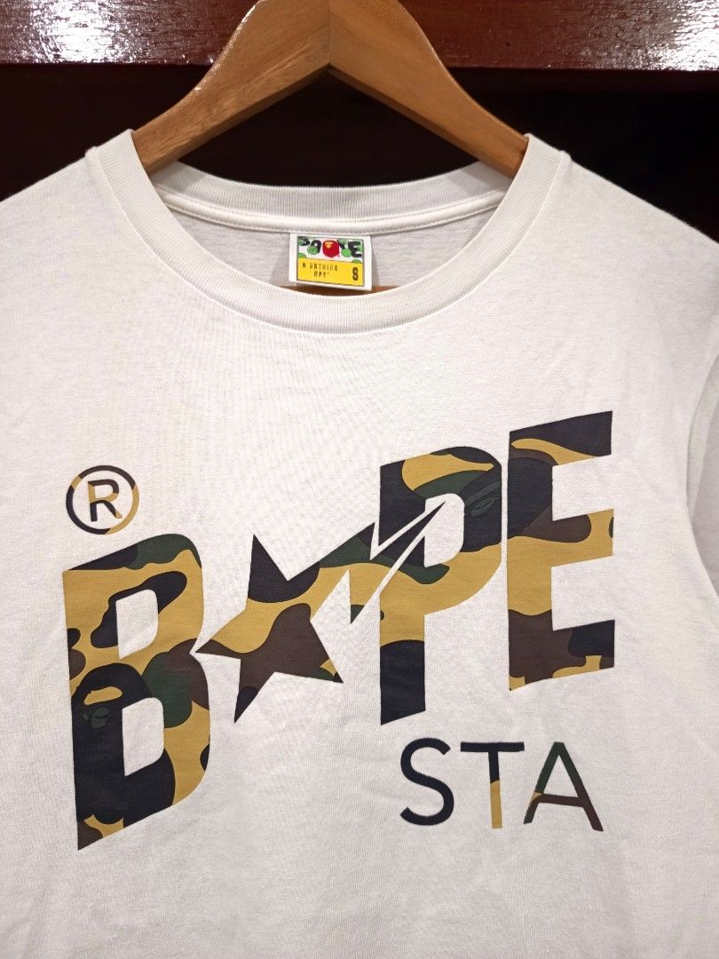 Bape Sta First Camo Script T Shirt (Category: Tshirts & Polo Shirts ) located in Dagupan City. Submitted by plugofallthreads (Listing ID 1466121956, Image 2). Description: Bape Sta First Camo Script T Shirt Size: Men's Small Length: 25 inches Width: 18 inches Authentic. In very good condition. 10/10 print. 9/10 cloth. Price: Php 1,500 plus sf DM TO PURCHASE.