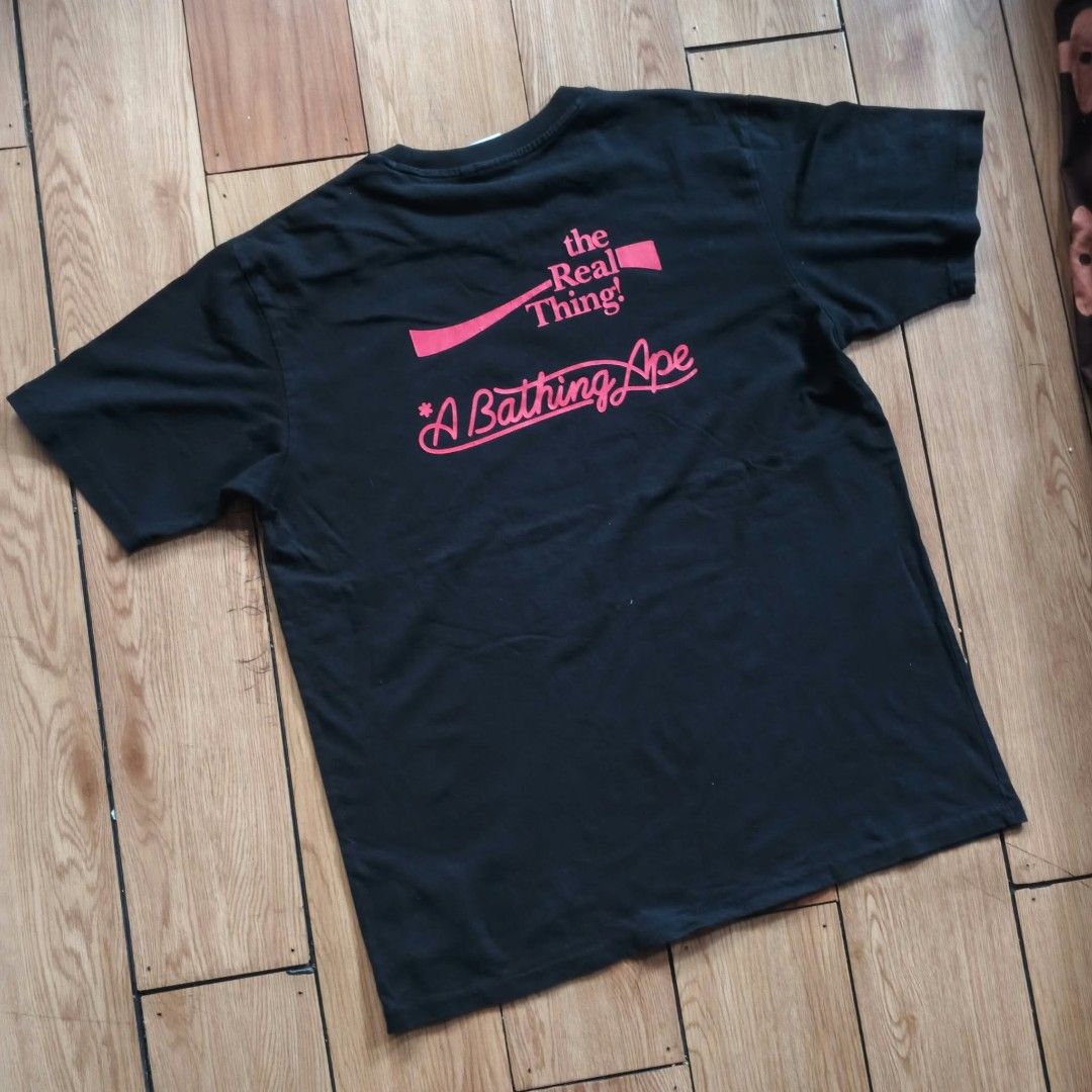 BAPE x Coca-Cola Black T-shirt (Category: Shirts) located in Paranaque City. Submitted by thriftine5 (Listing ID 1466009543, Image 3). Description: - Authentic BAPE x Coca-Cola collaboration t-shirt - Color: Classic Black - Material: Comfortable 100% Cotton - Front design: Iconic ape head filled with red star and lightning bolt graphics, plus Coca-Cola branding and woven hem tag - Back design: 'the Real Thing!' and 'A Bathing Ape' lettering - Det