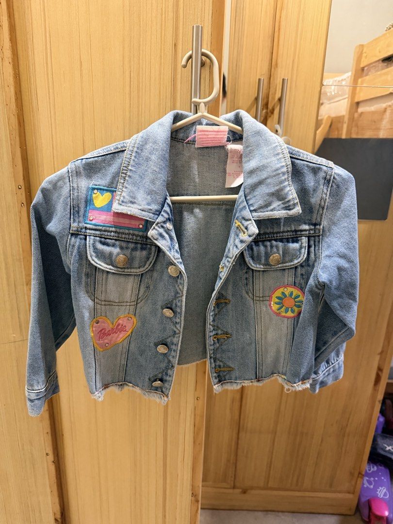 Barbie Avenue Kids Denim Jacket (Category: Babies & Kids Fashion) located in Quezon City. Submitted by welovedclothing (Listing ID 1466048749, Image 1). Description: - Brand: Barbie Avenue - Style: Kids light wash blue denim jacket - Details: Cute front and back patches including a heart and blue flower, raw frayed hem - Closures: Metal buttons down the front and on cuffs - Pockets: Two chest pockets with button flaps - Neckline: Classic collar -