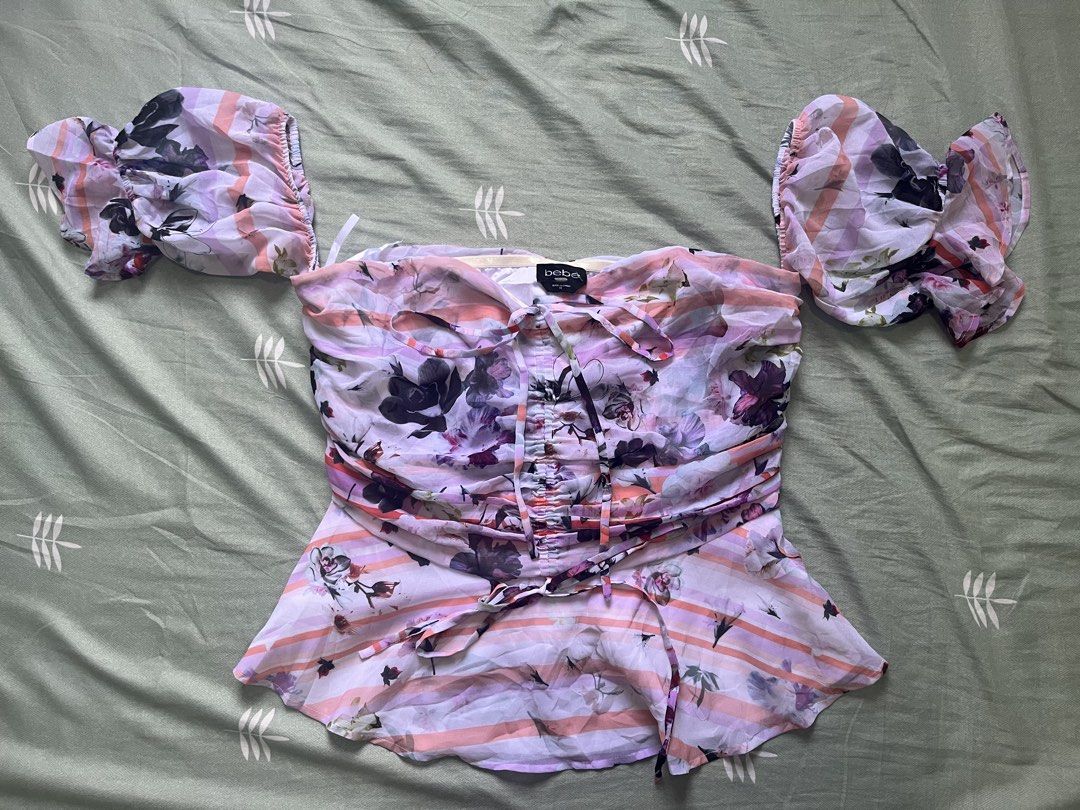 bebe floral off-shoulder top size 10 (Category: Blouses) located in Manila. Submitted by thrifted.shits (Listing ID 1466036993, Image 1). Description: - Brand: bebe - Size: 10 - Design: Pink & purple striped with vibrant all-over floral prints - Sleeves: Short puff sleeves with ruffled cuffs - Details: Center front ruching with drawstring ties & adjustable hem tie - Material: Lightweight, airy chiffon - Condition: like new - Perfect for: Date nig