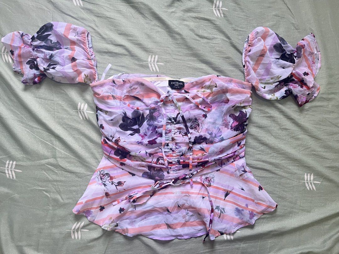 bebe floral off-shoulder top size 10 (Category: Blouses) located in Manila. Submitted by thrifted.shits (Listing ID 1466036993, Image 2). Description: - Brand: bebe - Size: 10 - Design: Pink & purple striped with vibrant all-over floral prints - Sleeves: Short puff sleeves with ruffled cuffs - Details: Center front ruching with drawstring ties & adjustable hem tie - Material: Lightweight, airy chiffon - Condition: like new - Perfect for: Date nig