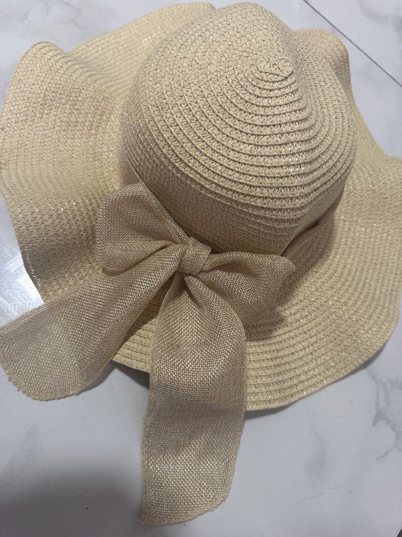 Beige Sun Hat with Large Ribbon (Category: Hats & Beanies) located in Manila. Submitted by decluterthings888 (Listing ID 1465956325, Image 1). Description: - Color: Neutral beige - Design: Wide brim with a stylish burlap-style bow - Material: Lightweight and easy to pack for trips - Perfect for: Beach days, park strolls, and summer outings - Versatile: Matches tons of summer outfits.