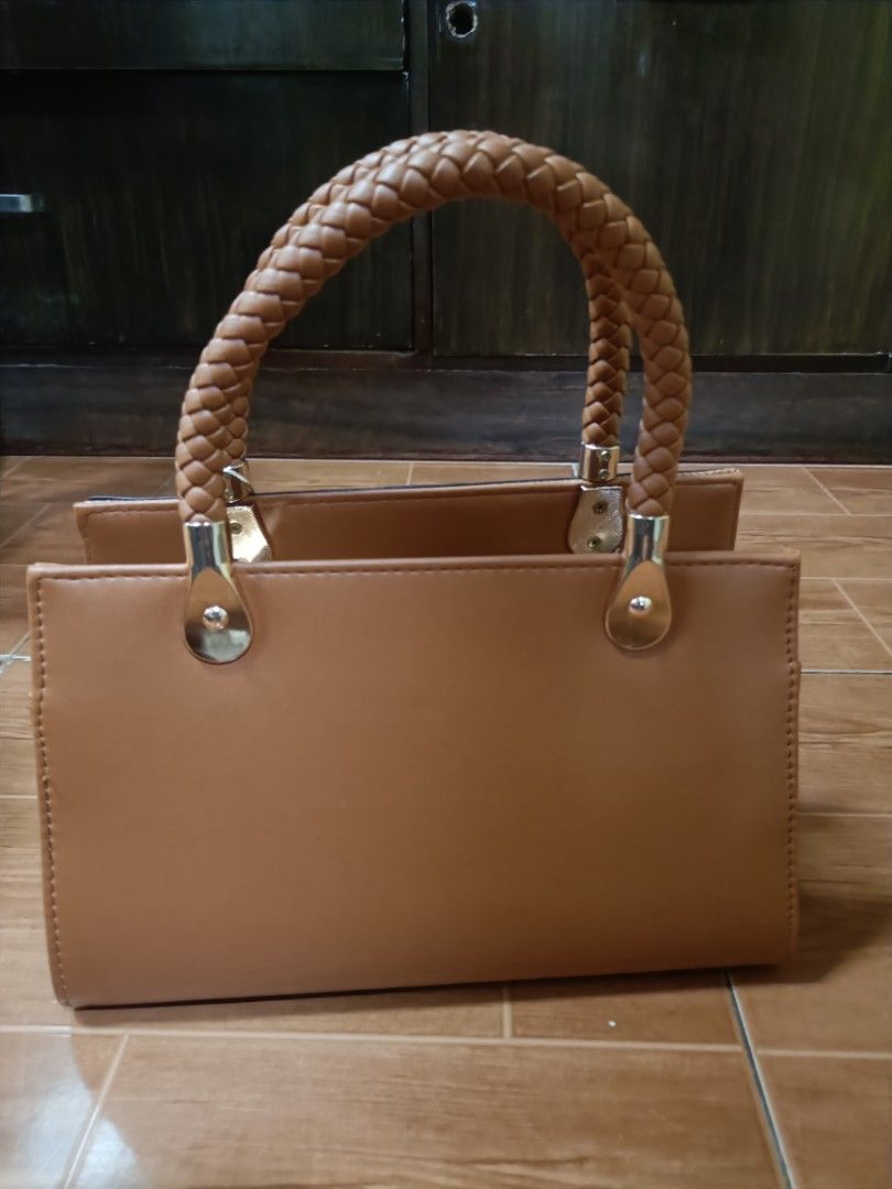 Belladonna Brown Braided Handle Handbag (Category: Shoulder Bags) located in Manila. Submitted by m4882 (Listing ID 1466154548, Image 2). Description: - Brand: Belladonna - Color: Brown - Design: Structured shape with a textured chevron front panel and smooth faux leather back - Handle: Braided top handle with elegant gold-tone hardware links - Closure: Zip-top main compartment - Accent: Signature pink brand tag on the front ring original price:1