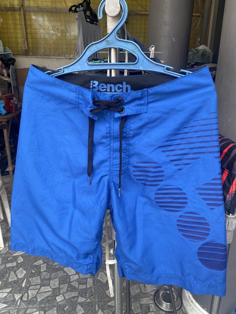 Bench Blue Board Shorts Size 30 (Category: Swim Trunks & Board Shorts) located in San Jose del Monte. Submitted by gigjhoe (Listing ID 1465987883, Image 1). Description: - Brand: Bench - Size: 30” -Length-21” - Color: Bright blue with graphic print on right leg - Details: Black inner waistband with large Bench logo, black drawstring with metal grommets - Origin: Made in China - Condition: Great option for swimming or beach days.
