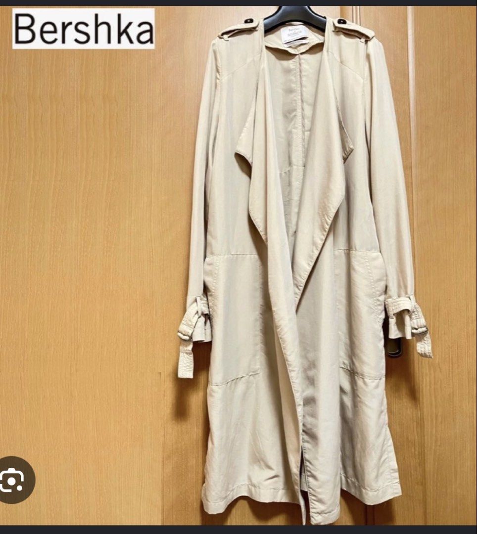 Bershka Beige Long Trench Coat (Category: Coats, Jackets and Outerwear) located in Rizal. Submitted by shoppables (Listing ID 1466085496, Image 2). Description: - Brand: Bershka - Color: Classic beige - Style: Lightweight draped front trench coat - Length: Long - Details: Shoulder epaulets and adjustable buckle sleeves - Condition: Clean, great overall - Perfect for: Cooler days and transitional weather.