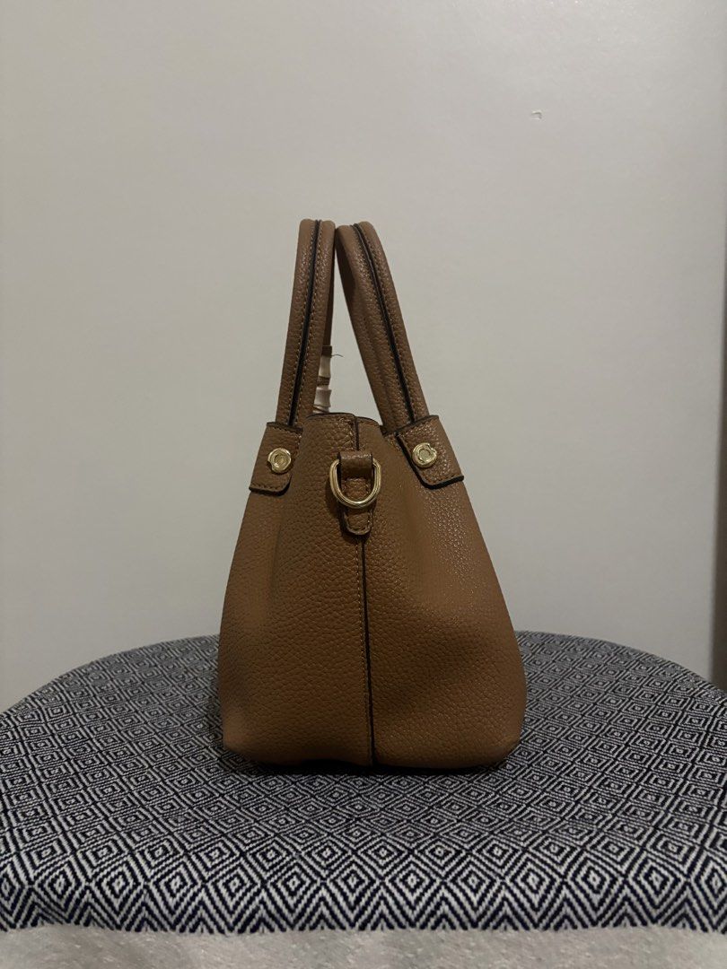 Bessie London Hand Bag with Strap (Category: Tote Bags) located in Makati City. Submitted by allaineallaine (Listing ID 1466115067, Image 2). Description: Bessi London Handbag - Rich brown pebble-textured finish with elegant gold-tone hardware - Versatile carrying options: dual top handles and a detachable shoulder strap - Chic matching patterned scarf included on the handle - Organized interior with a central zippered compartment and secure magn