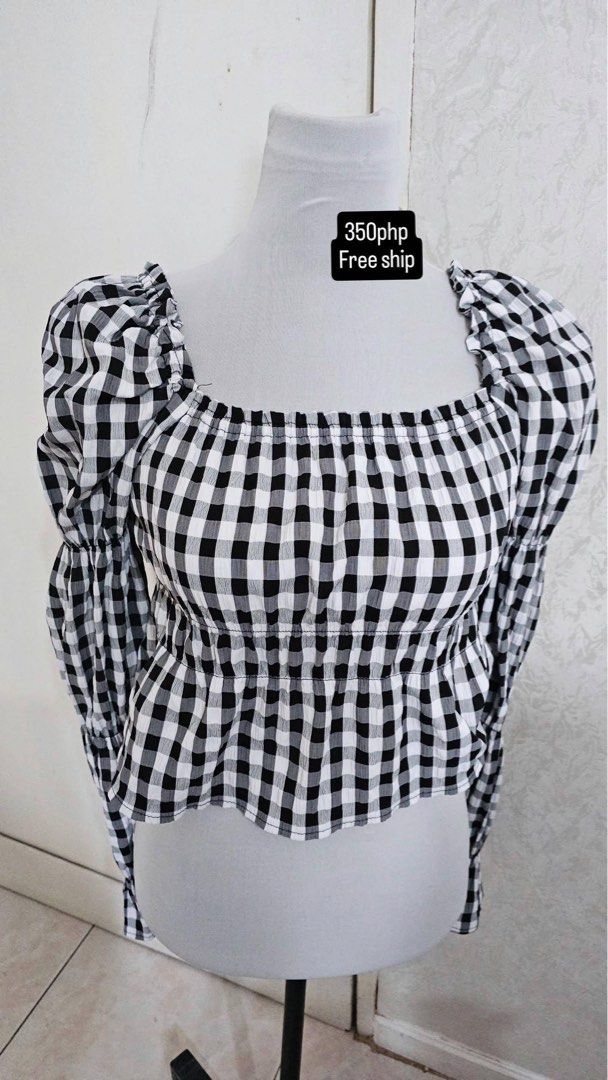 Black and White Gingham Square Neck Puff Sleeve Top (Category: Blouses) located in Cebu City. Submitted by cutexoxoshop (Listing ID 1465985411, Image 1). Description: - Style: Black and white gingham crop top - Details: Square neckline with ruffle trim, smocked bodice, and flared hem - Sleeves: Long puff sleeves with gathered shoulders - Fit & Comfort: Lightweight fabric, easy to pair with high-waisted jeans or skirts - Perfect for: Casual everyd
