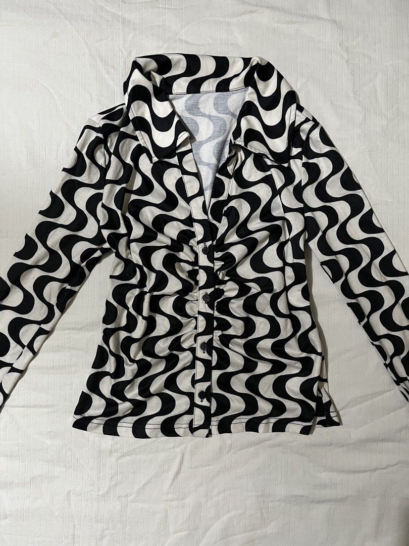 Black and White Swirl Print Button-Down Collared Blouse (Category: Blouses) located in Quezon City. Submitted by earthtodior (Listing ID 1466036885, Image 1). Description: - Style: Y2K inspired monochrome optical swirl long-sleeve top - Neckline: Plunging V-neck with trendy ruched details down the front center - Fit: Fitted cut with a five black button closure - Material: Stretchy, comfortable fabric with an all-over wavy graphic pattern - Perfec