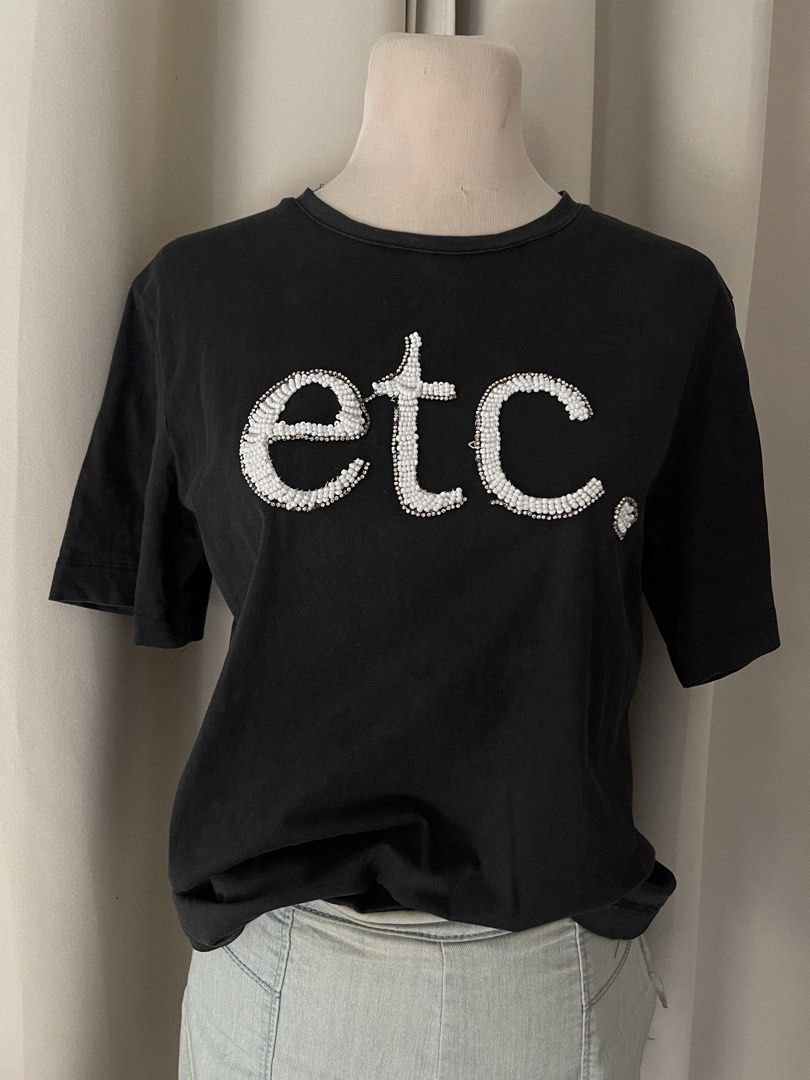 Black bune tees (Category: Shirts) located in Cainta. Submitted by zlove111 (Listing ID 1466114134, Image 3). Description: - Set of 2 black cotton t-shirts - Relaxed fit with crew neck and short sleeves - Tee 1: Features bold white beaded 'etc.' lettering on the chest - Tee 2: Features a striped 'STRESS' graphic with smaller text print - Easy to mix and match with jeans or shorts - Condition: No major flaws spotted up to semilarge cotton .