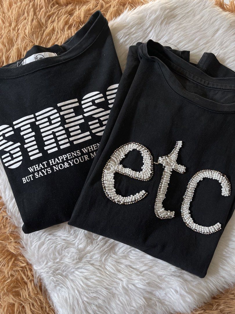 Black bune tees (Category: Shirts) located in Cainta. Submitted by zlove111 (Listing ID 1466114134, Image 1). Description: - Set of 2 black cotton t-shirts - Relaxed fit with crew neck and short sleeves - Tee 1: Features bold white beaded 'etc.' lettering on the chest - Tee 2: Features a striped 'STRESS' graphic with smaller text print - Easy to mix and match with jeans or shorts - Condition: No major flaws spotted up to semilarge cotton .