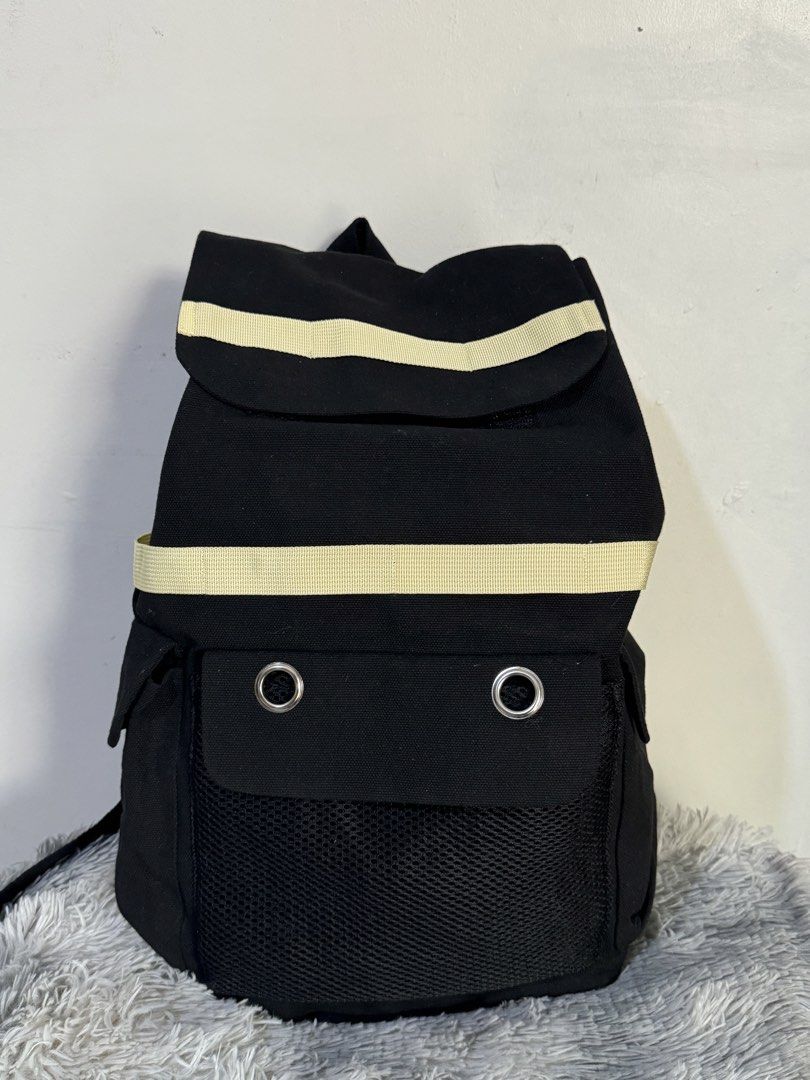 Black Canvas Backpack with Colorful Striped Accent Straps (Category: Backpacks) located in Urdaneta. Submitted by kathleenja24136 (Listing ID 1465957950, Image 3). Description: Solid black canvas backpack with vibrant striped straps across the top flap and front body. Main flap closure with buckle straps underneath. Front pocket features two metal grommet eyelets and a mesh lower section. Adjustable shoulder straps on the back. Sturdy fabric cons