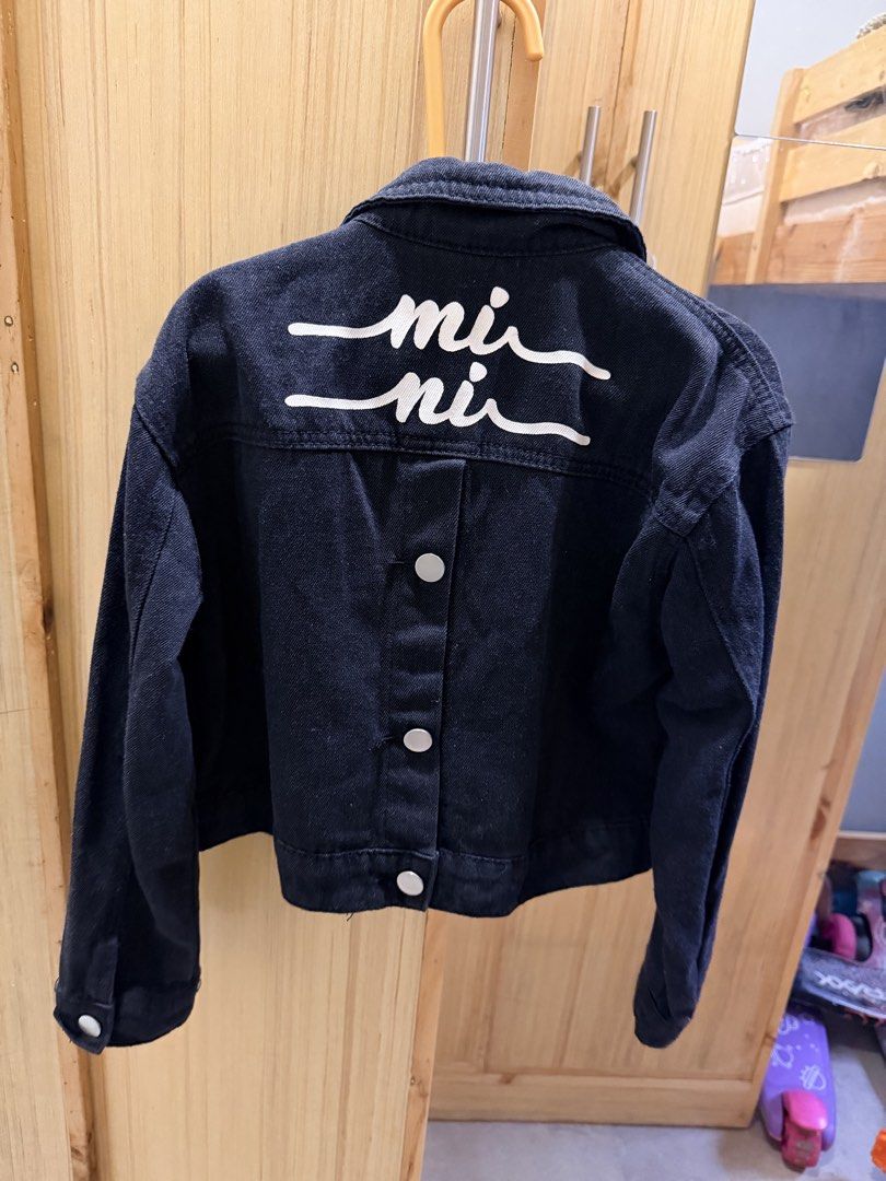 Black Denim Jacket Size 8-9Y (Category: Babies & Kids Fashion) located in Quezon City. Submitted by welovedclothing (Listing ID 1466048453, Image 3). Description: - Size: 8-9 years - Color: Black denim with white graphic text on the back - Closure: Front button closure - Pockets: Convenient chest pockets - Design: Classic collar and long sleeves with button cuffs - Material: Sturdy fabric, great for cooler weather.