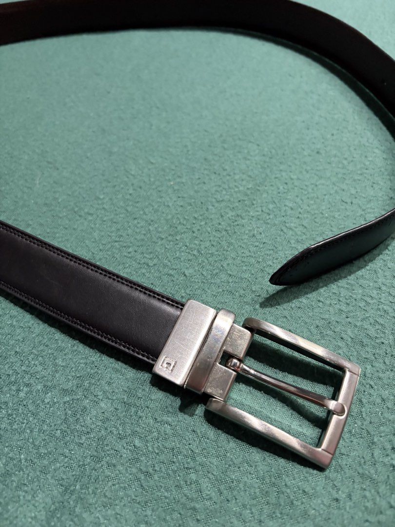 Black Leather Belt with Silver Buckle (Category: Belts) located in Guihulngan. Submitted by fbthriftgoodsniace (Listing ID 1465979169, Image 2). Description: Classic black leather belt with contrast stitching along the edges. Includes a rectangular silver-tone metal buckle featuring a small engraved logo detail. Clean strap with standard punch holes on the other end. Clean, minimalist daily wear accessory that goes well with casual or formal outf