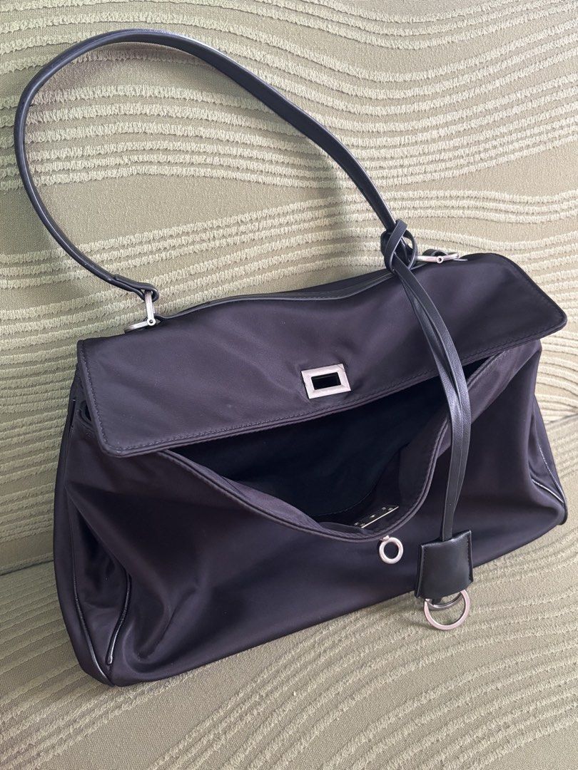 Black Nylon Shoulder Bag With Silver Hardware (Category: Shoulder Bags) located in Batangas. Submitted by missraee (Listing ID 1466003717, Image 2). Description: - Color & Material: Sleek black nylon with sturdy structure - Design: Flap top with a modern rectangular silver metal closure - Straps: Single black shoulder strap with silver hardware and edgy hanging rings detail - Interior: Open main compartment for easy access - Capacity: Ideal size 