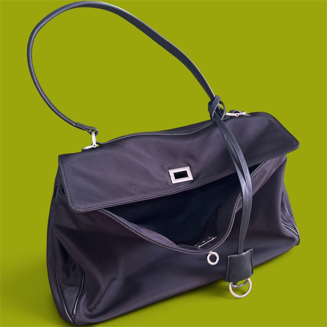 Black Nylon Shoulder Bag With Silver Hardware (Category: Shoulder Bags) located in Batangas. Submitted by missraee (Listing ID 1466003717, Image 1). Description: - Color & Material: Sleek black nylon with sturdy structure - Design: Flap top with a modern rectangular silver metal closure - Straps: Single black shoulder strap with silver hardware and edgy hanging rings detail - Interior: Open main compartment for easy access - Capacity: Ideal size 