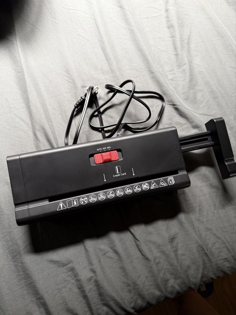 Black Portable Strip-Cut Paper Shredder with Extendable Arm (Category: Office & Business Technology) located in Taguig. Submitted by ajiichaban (Listing ID 1465974030, Image 2). Description: - Type: Compact black strip-cut shredder - Capacity: Shreds up to 6 sheets of paper and credit cards at once - Design: Features an extendable arm to fit over most bins - Controls: Top switch with Auto, Off, and Rev settings - Condition: Clean and works great,