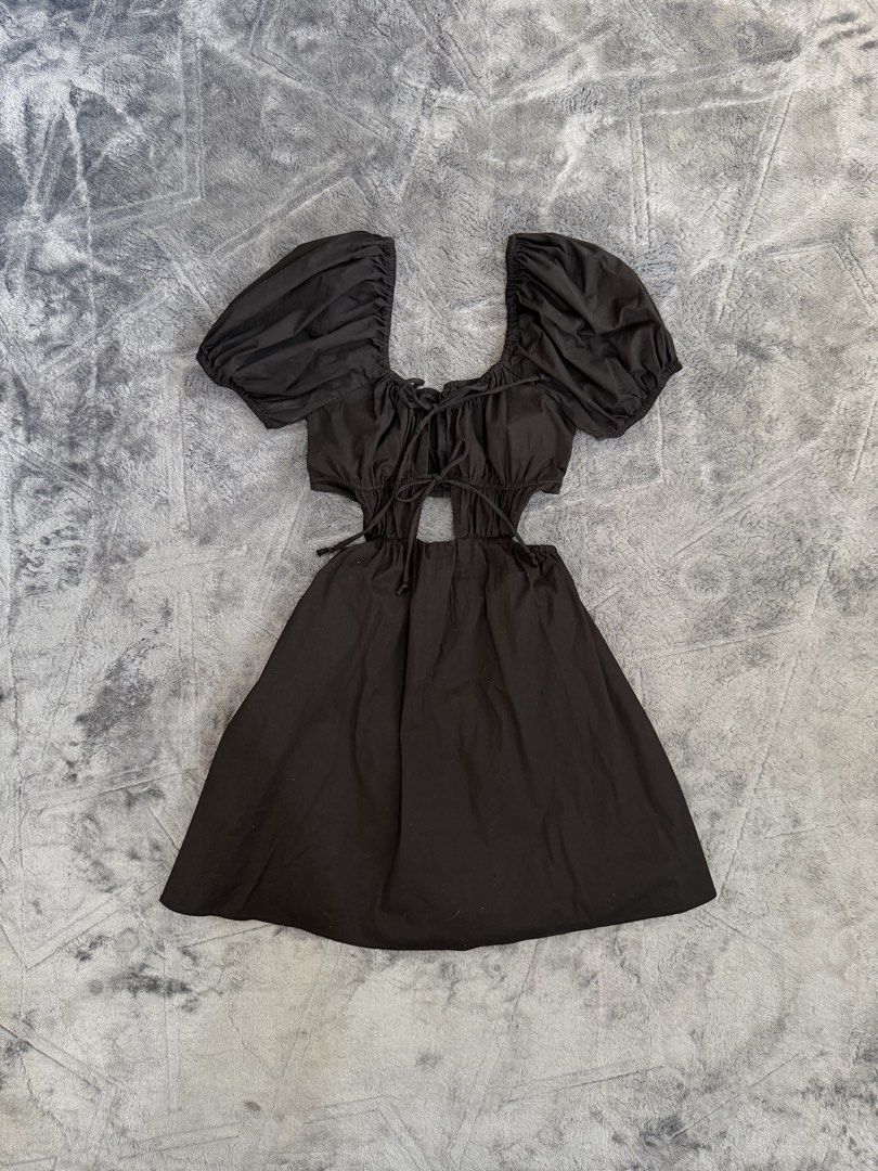 Black Puff Sleeve Cutout Mini Dress (Category: Dresses) located in Manila. Submitted by yeti_it (Listing ID 1466059817, Image 2). Description: - Color & Style: Black mini dress with flared skirt, perfect for a night out - Neckline & Sleeves: Square neckline with cute front tie details and short puff sleeves - Trendy Details: Cutout sections at the waist with adjustable side ties - Material: Comfortable 100% cotton fabric .