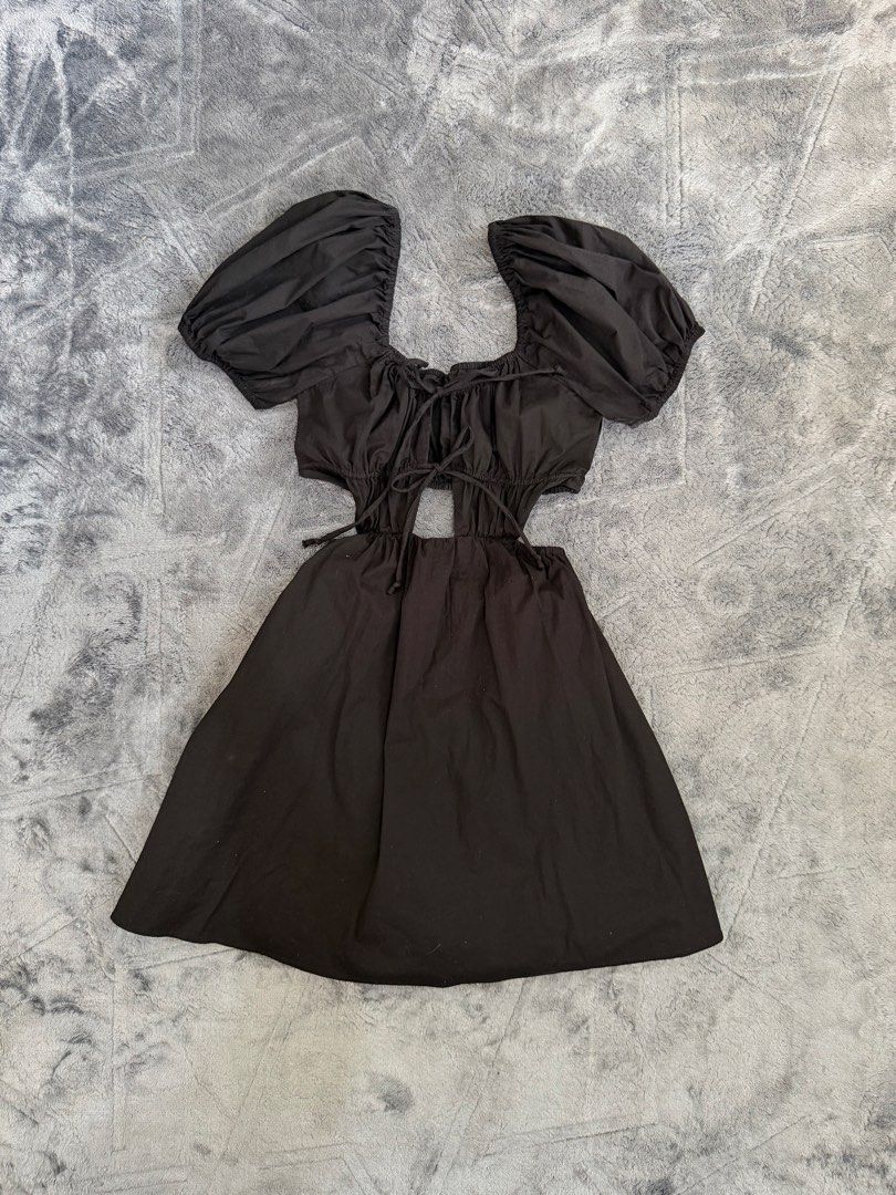 Black Puff Sleeve Cutout Mini Dress (Category: Dresses) located in Manila. Submitted by yeti_it (Listing ID 1466059817, Image 1). Description: - Color & Style: Black mini dress with flared skirt, perfect for a night out - Neckline & Sleeves: Square neckline with cute front tie details and short puff sleeves - Trendy Details: Cutout sections at the waist with adjustable side ties - Material: Comfortable 100% cotton fabric .