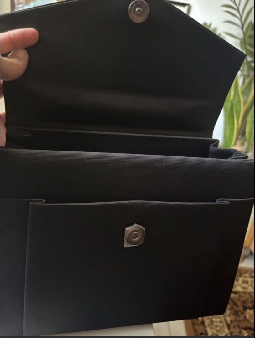 Black structured handbag with top handle and magnetic closure (Category: Tote Bags) located in Taguig. Submitted by macxdinglas (Listing ID 1465992989, Image 3). Description: - Classic black handbag with a sleek, structured design - Secure flap front with magnetic snap closure - Single top handle for effortless carrying - Multiple interior compartments for easy organization - Clean fabric lining throughout - Versatile size and style for daily use