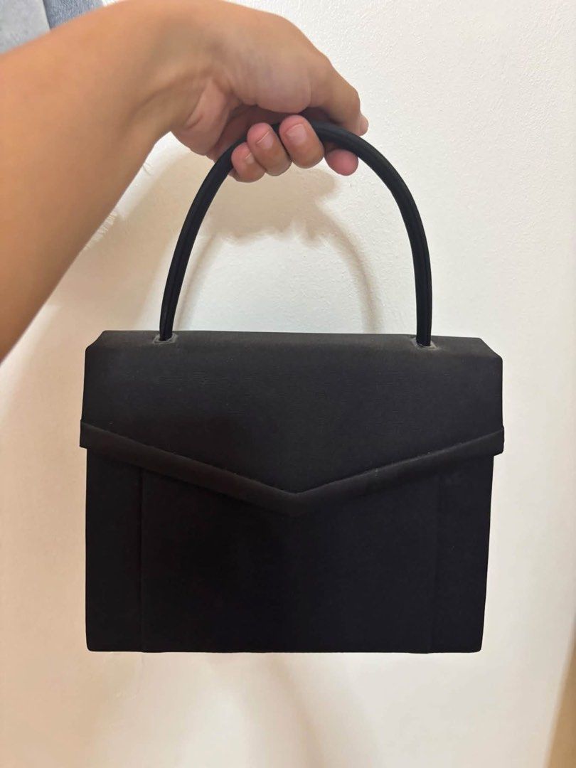 Black structured handbag with top handle and magnetic closure (Category: Tote Bags) located in Taguig. Submitted by macxdinglas (Listing ID 1465992989, Image 1). Description: - Classic black handbag with a sleek, structured design - Secure flap front with magnetic snap closure - Single top handle for effortless carrying - Multiple interior compartments for easy organization - Clean fabric lining throughout - Versatile size and style for daily use