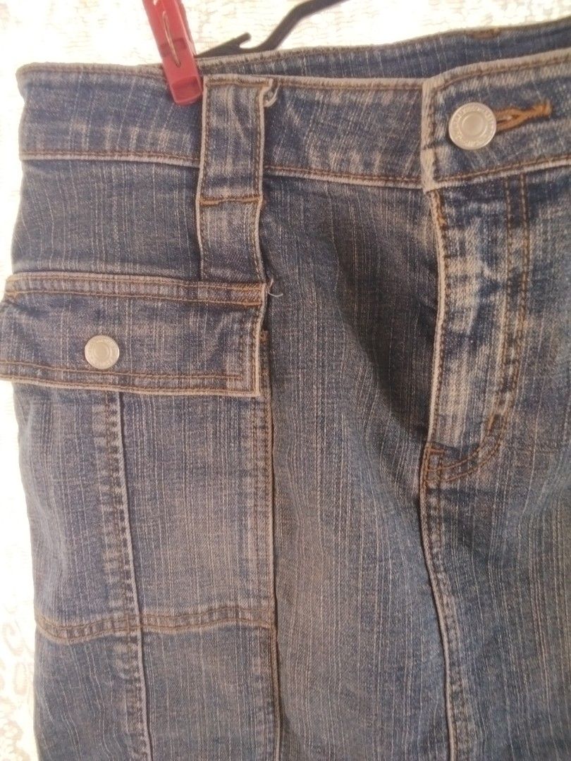Blue denim cargo skirt with button pockets (Category: Skirts) located in Alaminos. Submitted by dangpreloved01 (Listing ID 1465969147, Image 2). Description: Mid-wash blue denim mini skirt with contrast stitching. Utility style cargo pockets on the front and back, secured with metal snap buttons. Sturdy belt loops and front button fly closure. Classic Y2K aesthetic, great for pairing with boots or sneakers. Clean hems and solid denim fabric..