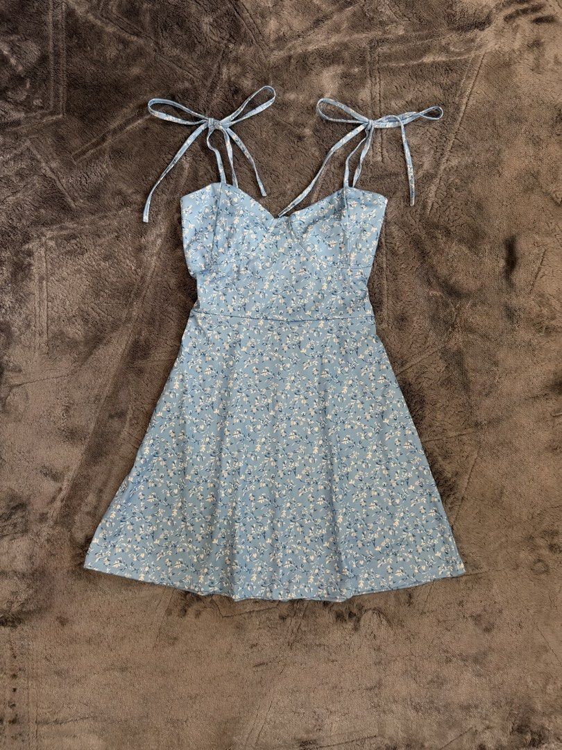 Blue Floral Tie-Strap Mini Dress (Category: Dresses) located in Manila. Submitted by yeti_it (Listing ID 1466058353, Image 1). Description: - Color & Pattern: Light blue with small white flowers - Neckline: Sweetheart neckline with molded cups - Straps: Adjustable tie straps at the shoulders - Fit & Style: A-line flared skirt, short mini length - Closure: Back zipper closure - Perfect for: Summer outings and casual dates.