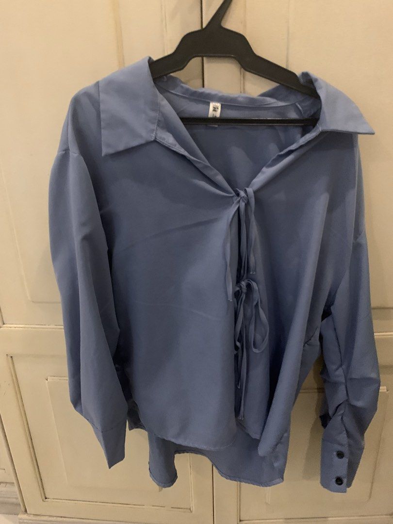 Blue long sleeve blouse with front tie ribbons (Category: Longsleeves) located in Manila. Submitted by pureforest_68db5f (Listing ID 1466076637, Image 2). Description: - Color: Light blue - Fit: Relaxed, oversized - Features: Front tie-up ribbon detail, long sleeves with button cuffs, classic pointed collar - Fabric: Soft and comfortable - Styling: Versatile; easy to dress up with trousers or keep casual with shorts.