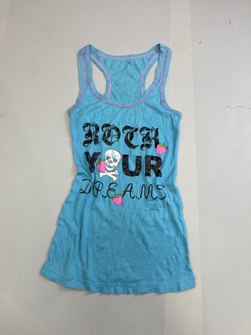 Blue Skull Strawberry Racerback Tank Top (Category: Sleeveless) located in Mabalacat. Submitted by aas_thriftfings (Listing ID 1465992472, Image 1). Description: - Bright blue racerback tank top - Pink contrast trim along neckline and straps - Distressed 'ROCK YOUR DREAMS' graphic with strawberry and skull details - Soft cotton ribbed fabric with a fitted silhouette - Great casual layering piece.