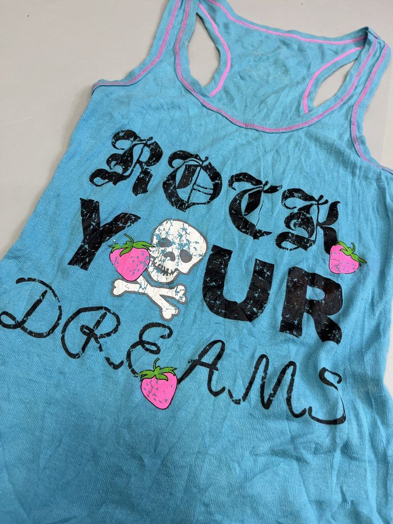 Blue Skull Strawberry Racerback Tank Top (Category: Sleeveless) located in Mabalacat. Submitted by aas_thriftfings (Listing ID 1465992472, Image 2). Description: - Bright blue racerback tank top - Pink contrast trim along neckline and straps - Distressed 'ROCK YOUR DREAMS' graphic with strawberry and skull details - Soft cotton ribbed fabric with a fitted silhouette - Great casual layering piece.